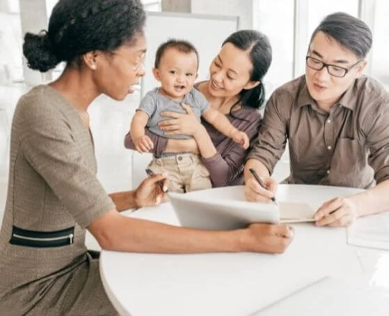 couple-with-kid-signing-life-insurance-policy-in-front-of-insurance-agent