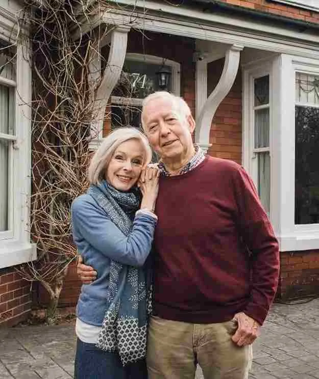 old-couple-standing-front-of-home