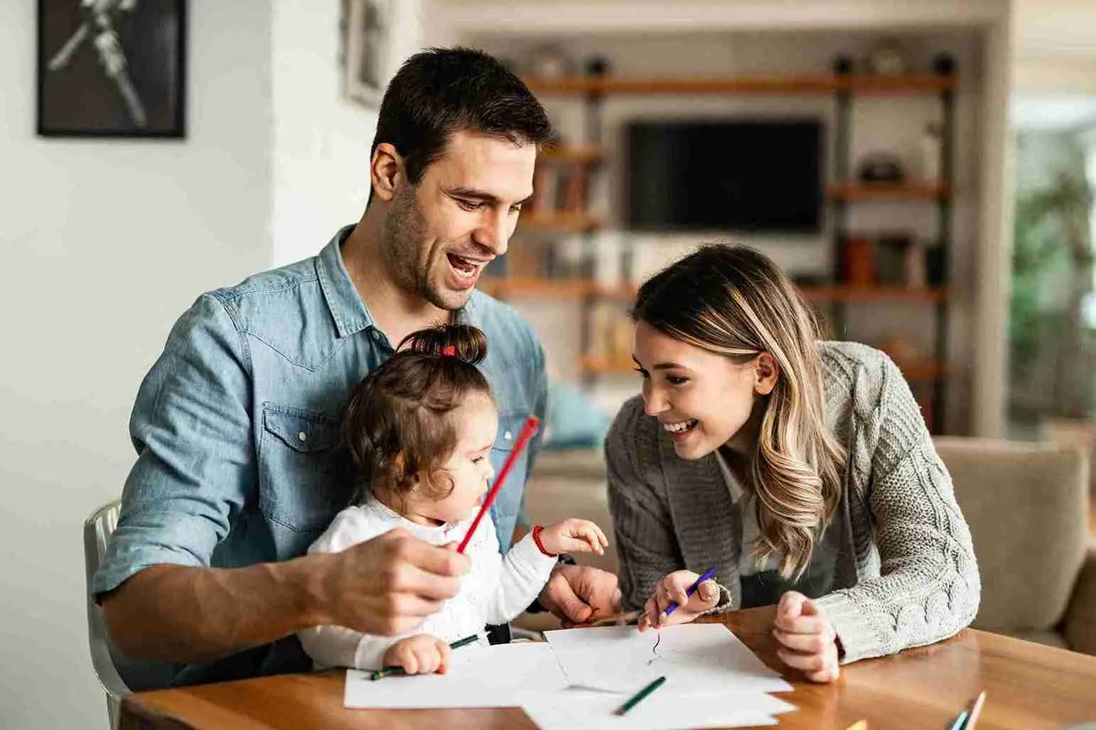 happy-parents-their-small-daughter-having-fun-while-coloring-paper