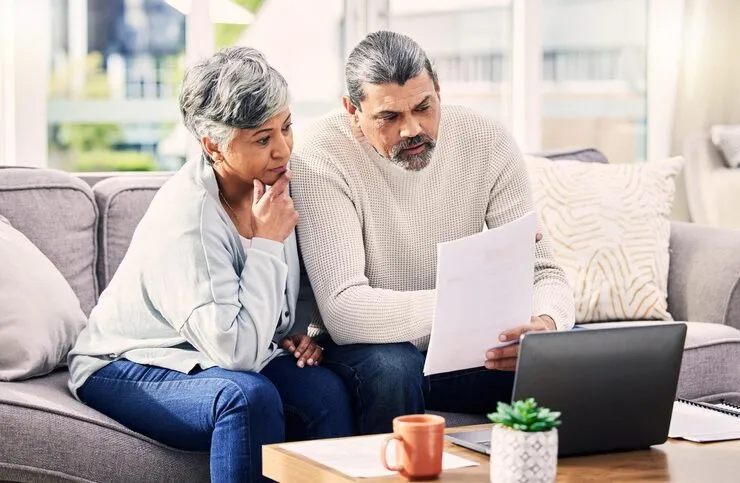 old-couple-laptop-retirement-paperwork-life-insurance-with-finance-investment-together-home-people-taxes-online-pension-policy-documents